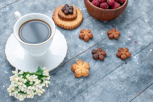 xícara de café junto com bolinhos e frutas vermelhas em um biscoito de massa