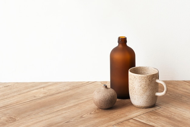 Foto grátis xícara de café mínima perto de um vaso marrom no chão de madeira