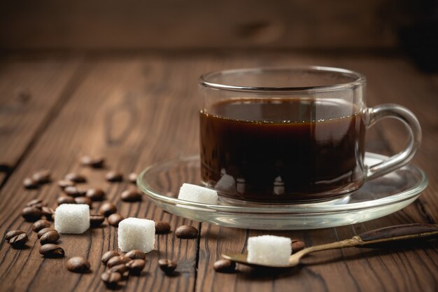 Xícara de café preto na mesa de madeira.