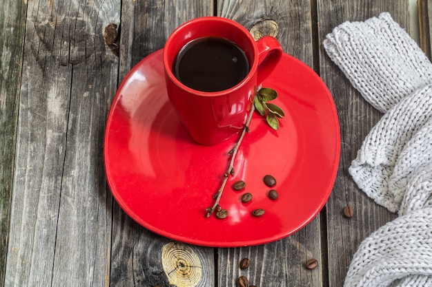 Xícara de café vermelha em um prato linda parede de madeira