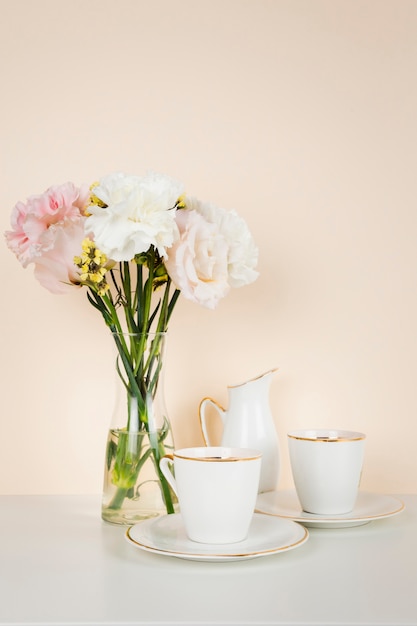 Xícara de chá ao lado do buquê de flores