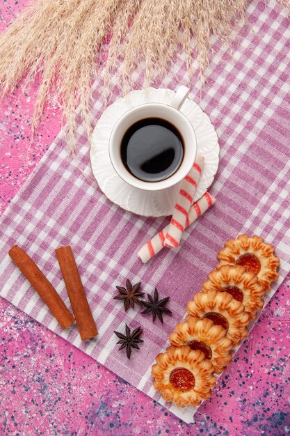 Xícara de chá com biscoitos e canela na mesa rosa biscoito doce de açúcar