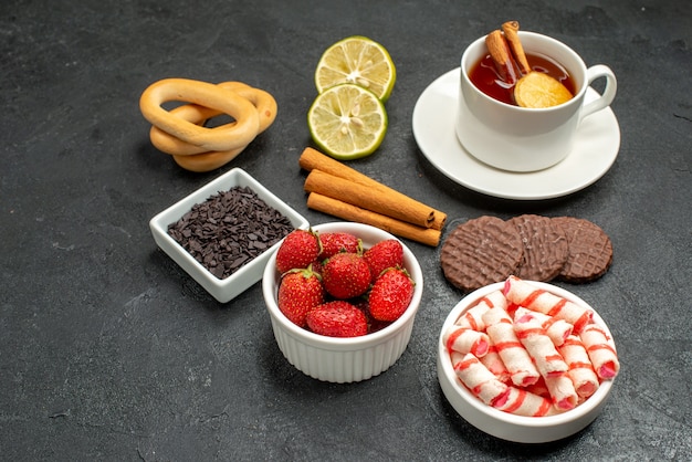 Xícara de chá com biscoitos e doces de frente