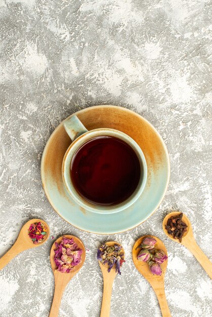 Xícara de chá com flores secas na superfície branca chá com sabor de flor