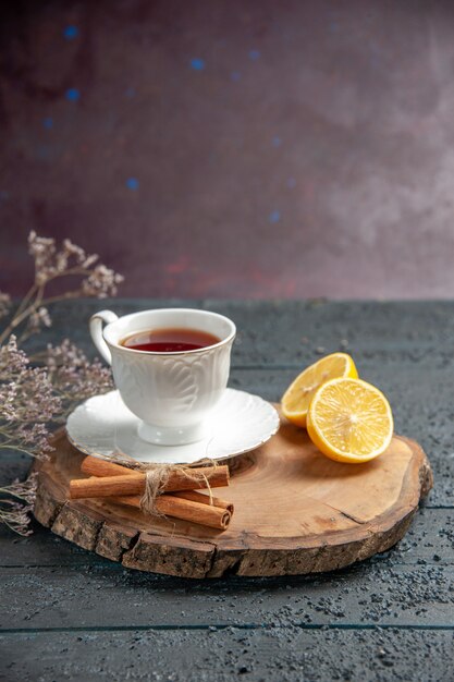 Xícara de chá com limão em fundo escuro de vista frontal