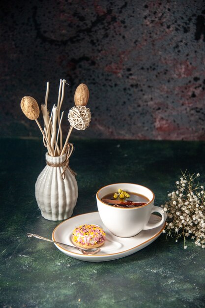 Foto grátis xícara de chá com um pequeno biscoito doce no prato na parede escura copo de cerimônia doce café da manhã bolo foto manhã sobremesa cores