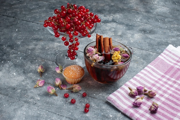 Xícara de chá de vista frontal com bolo de canela e cranberries vermelhas frescas na mesa cinza açúcar chá fruta baga