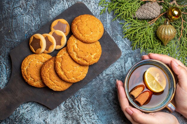 Xícara de chá de vista superior com biscoitos doces no fundo claro