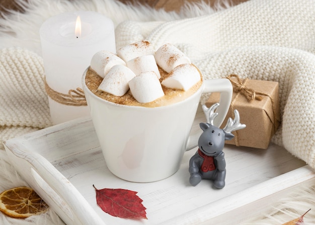 Xícara de chocolate quente com marshmallows e presente na bandeja