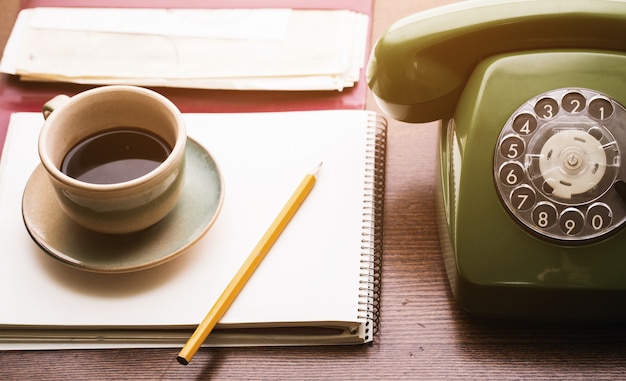 Xícara de telefone retro, notebook e café