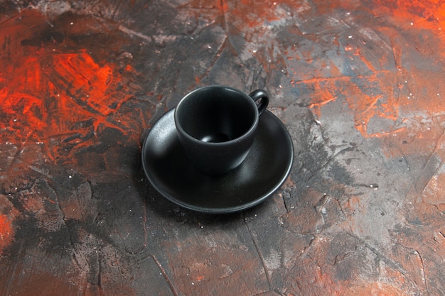 Foto grátis xícara e pires pretos em uma mesa escura com vista de baixo
