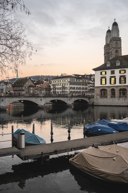 Zurique, Suíça com a ponte Munsterbrucke sobre o rio Limmat