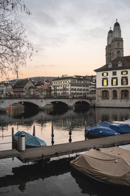 Zurique, Suíça com a ponte Munsterbrucke sobre o rio Limmat