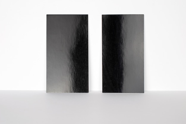 2 leere schwarze Visitenkarten an der weißen Wand, 3,5 x 2 Zoll groß