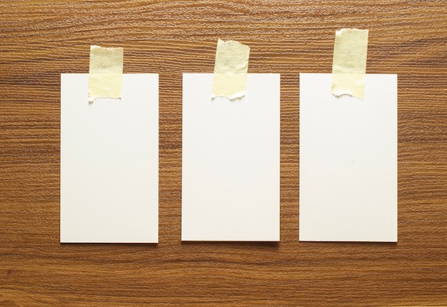3 leere Visitenkarten mit gelbem Klebeband auf eine Holzoberfläche geklebt, 3,5 x 2 Zoll groß
