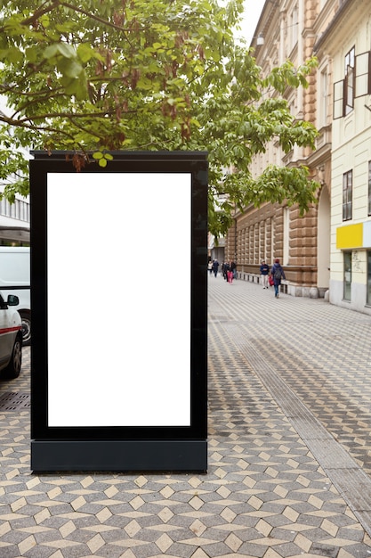 3D-Illustration. Vertikale Werbetafel mit Modellplatz für Ihre Werbung gegen Stadtraum. Leerer Werbeständer. Öffentliche Informationstafel über städtische Umgebung. Vitrine. Stadtbild