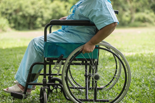 Abschluss oben Einsame ältere Frau, die auf Rollstuhl am Garten im Krankenhaus sitzt