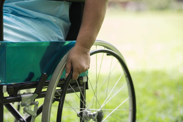 Abschluss oben Einsame ältere Frau, die auf Rollstuhl am Garten im Krankenhaus sitzt