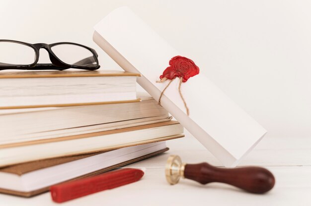 Abschlusszeugnis und Stapel Bücher