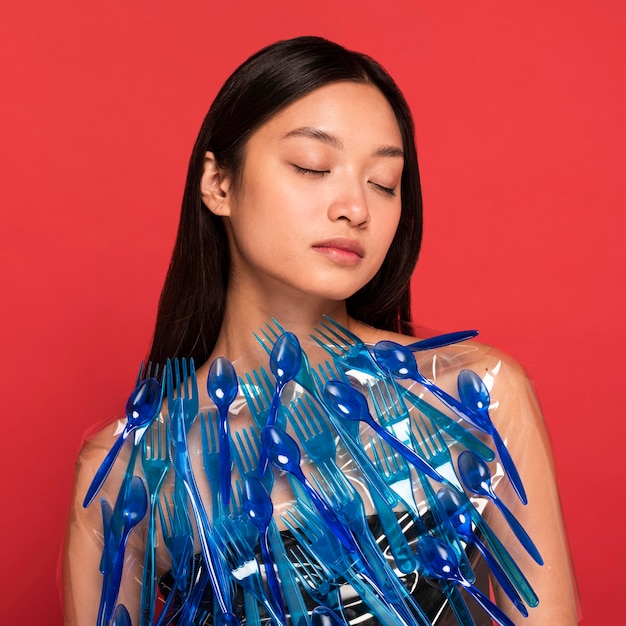 Kostenloses Foto abstrakte darstellung des blauen plastikmülls auf frau