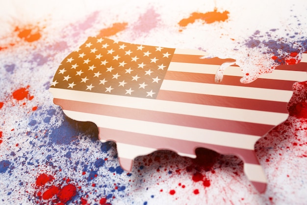 Abstrakte Explosion von rotem und blauem holifarbenem Pulver mit der USA-Karte zum Gedenken an den Unabhängigkeitstag