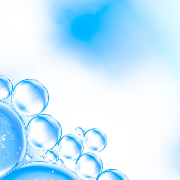 Abstrakte Luftblasen im Wasser auf hellem Cyan-Blau verwischten Hintergrund