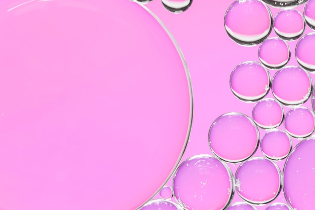 Abstrakte Luftblasen in der Flüssigkeit auf rosa Hintergrund