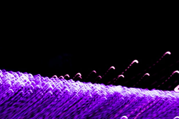 Abstrakte purpurrote helle Spuren auf schwarzem Hintergrund