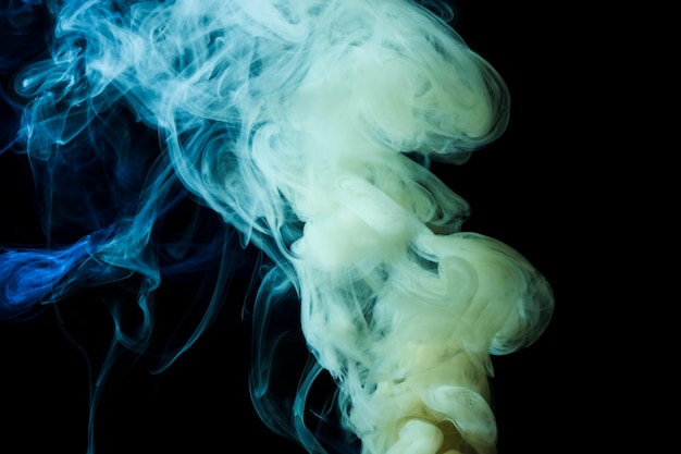 Abstrakter weißer und blauer dichter Rauch wirbelt auf schwarzem Hintergrund