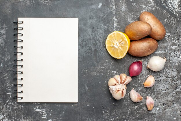 Abwechslungsreiches Essen und Notizbuch auf dunklem Hintergrund