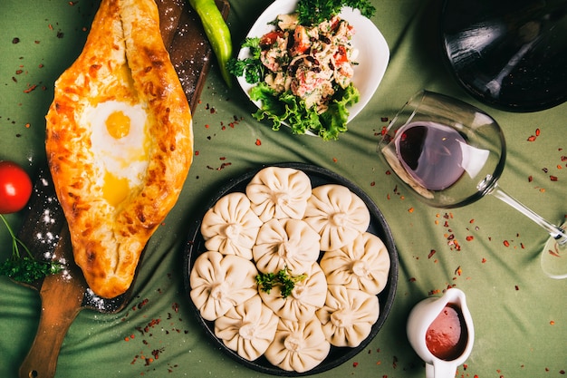 Adjarian khachapuri und khinkali serviert mit sauce und salat