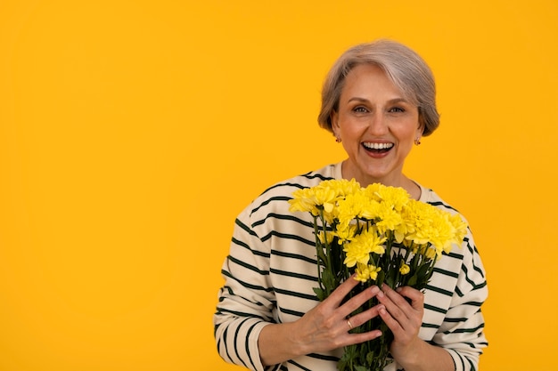 Ältere Frau der Vorderansicht, die mit Blumen aufwirft