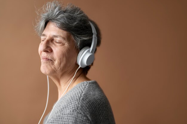 Ältere Frau des mittleren Schusses mit Kopfhörern