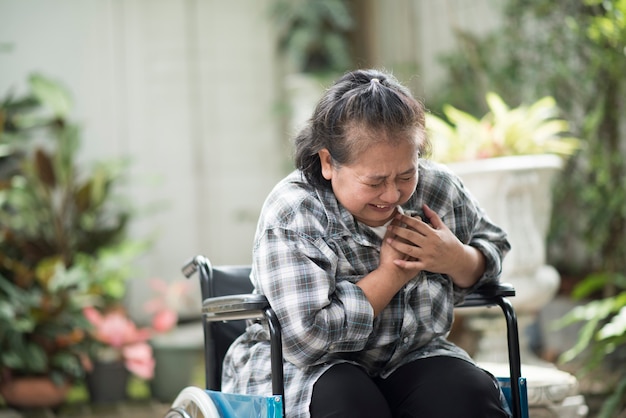 ältere Frau haben Herzkrankheit, die auf Rollstuhl sitzt
