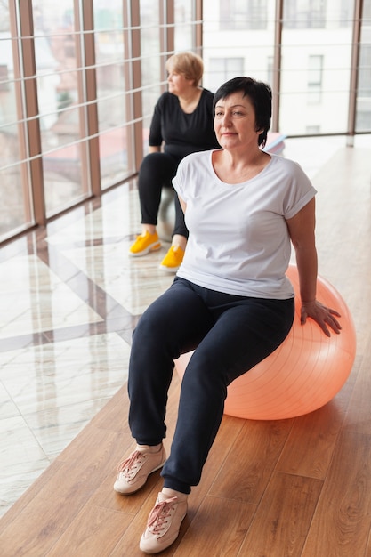 Ältere frau im fitnessstudio am ball