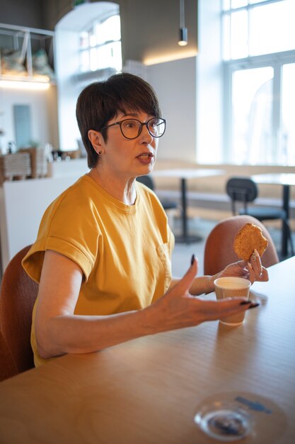 Kostenloses Foto Ältere frau spricht und trinkt kaffee