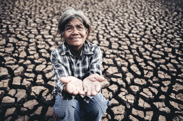 Kostenloses Foto Ältere frauen machen hände, um regenwasser bei trockenem wetter, globaler erwärmung, vorgewählter fokus zu erhalten.