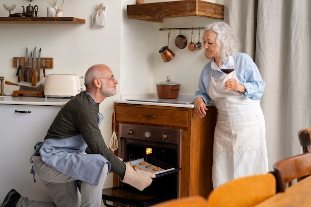 Kostenloses Foto Ältere paare, die zusammen in der küche kochen