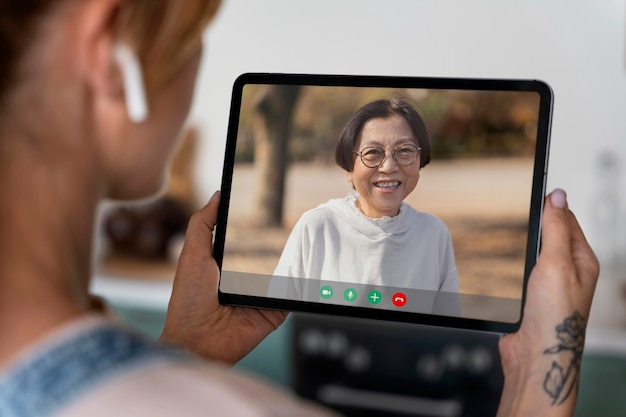 Kostenloses Foto Ältere person, die die videoanruffunktion auf ihrem gerät verwendet
