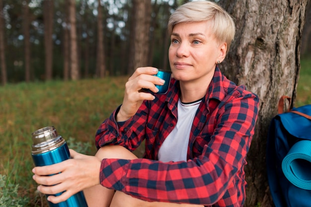 Kostenloses Foto Ältere touristenfrau, die im freien hydratisiert hält