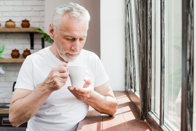 Älterer Mann, der einen Kaffee trinkt