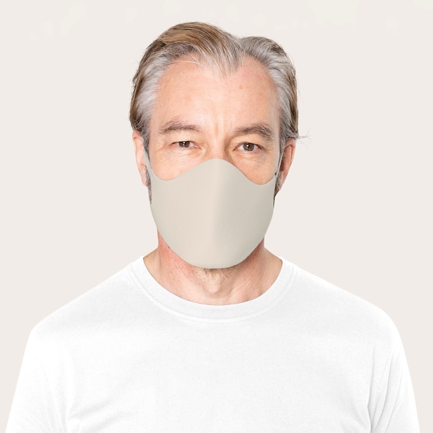 Älterer mann mit beiger gesichtsmaske covid-19-kampagne mit designraum