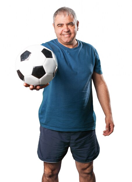 Älterer Mann mit einem Fußball in seinen Händen