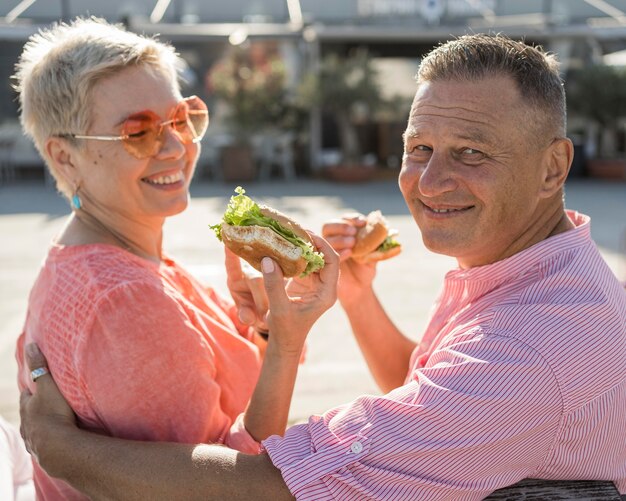 Älteres Paar am Strand genießt einen schönen Burger