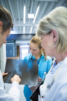 Ärzteteam diskutiert über röntgenbericht im korridor
