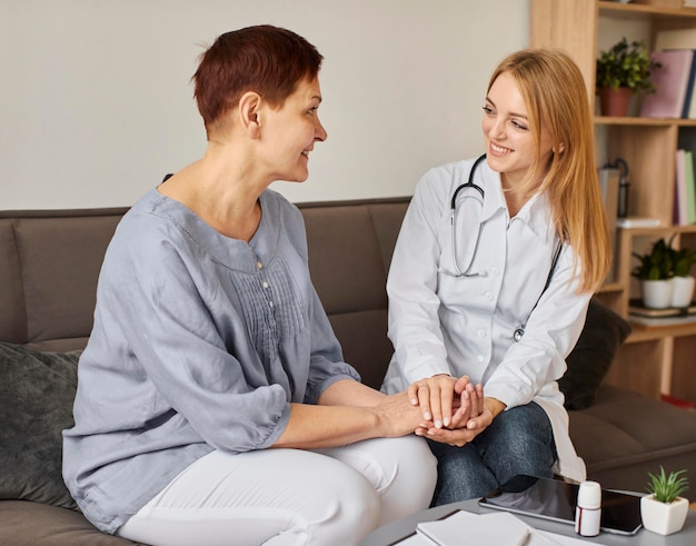 Kostenloses Foto Ärztin des smiley covid recovery centers, die ältere patienten überprüft