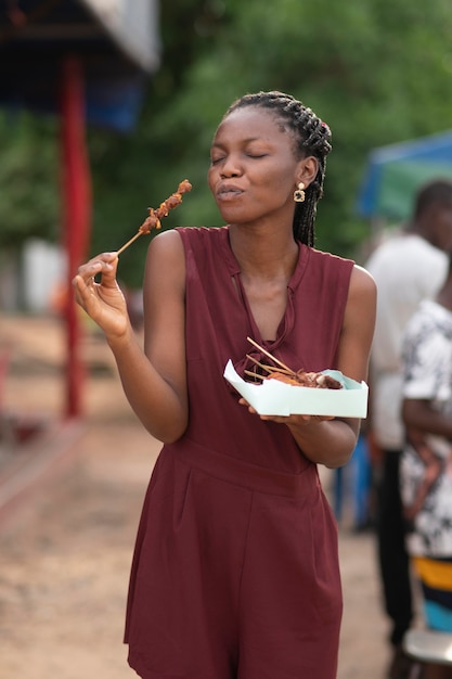 Kostenloses Foto afrikanerin, die straßenessen isst