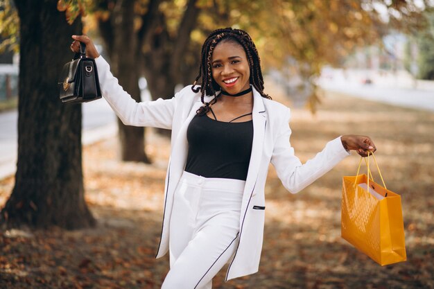 Afrikanerin mit gelben Einkaufstaschen im Park