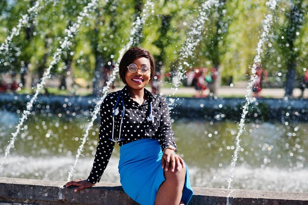 Afrikanisch-amerikanische Ärztin mit Stethoskop stellte im Freien Hintergrundbrunnen auf