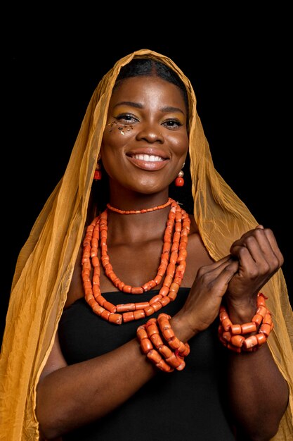 Afrikanische Frau, die traditionelle Accessoires und gelben Schleier trägt